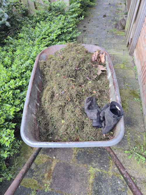 kruiwagen vol troep van klein grasveld